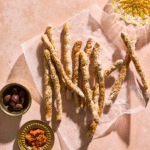 Sprøde fuldkornsgrissini med sesam serveret som snack sammen med dip.