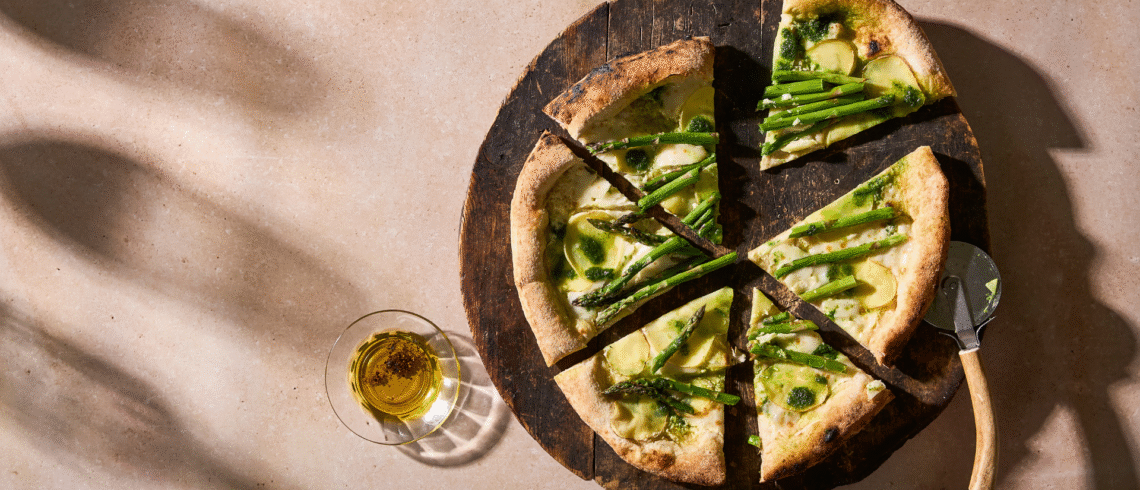 Hjemmelavet pizza toppet med kartofler, grønne asparges og pesto.