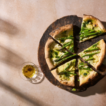 Hjemmelavet pizza toppet med kartofler, grønne asparges og pesto.