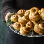 Luciabrød på en bagerist holdt af en person, der serverer de nybagte brød.